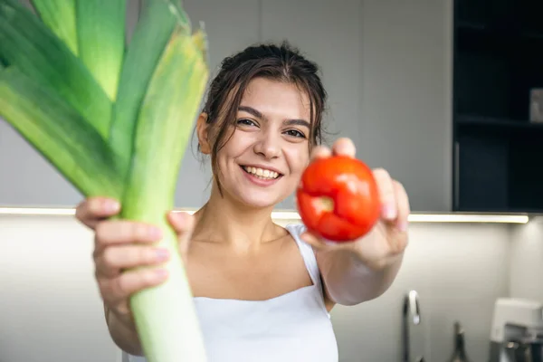 Jovencita Alegre Cocina Sosteniendo Puerro Tomate Sus Manos Concepto Alimentación — Foto de Stock