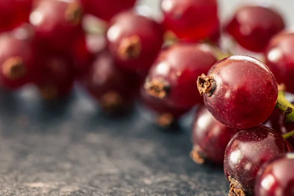 Red currant berries on a textured surface, macro shot.