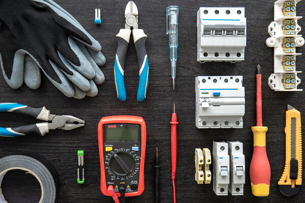 Flat lay composition with electrical tools on wooden background.