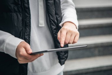 Kapatın, kadın tablet kullanıyor, şehir arka planı bulanık, vücut parçası.