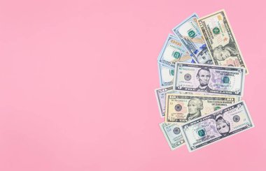 Pembe zemin üzerinde dolar banknotları, düz döşeme, kopyalama alanı.