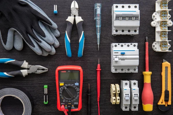 Flat lay composition with electrical tools on wooden background.