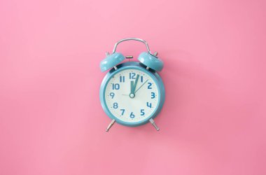 Pembe zemin üzerindeki mavi alarm saati izole, düz konum, zaman yönetimi konsepti.