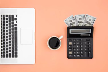 Hesap makinesi, laptop, kahve fincanı ve dolar banknotları renkli arka plan, düz yatak, bütçe planlaması konsepti, para kazanmak, vergi hesapları.