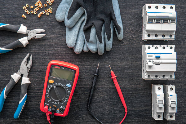 Flat lay composition with electrical tools on wooden background.
