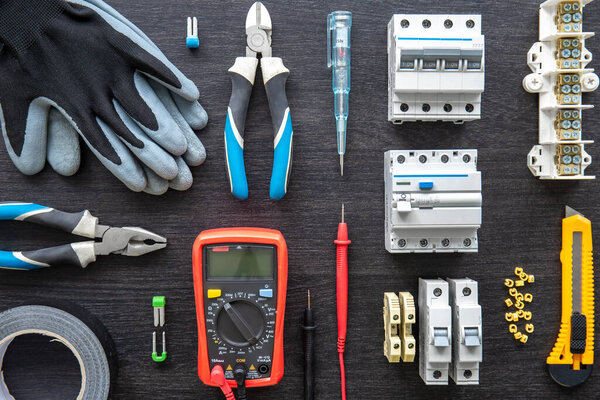 Flat lay composition with electrical tools on wooden background.