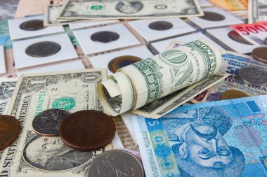 Bir büyüteçle farklı koleksiyoncu paraları ve banknotların arka planı, üst görünüm