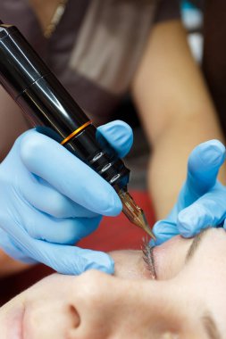 İçinde iğne bulunan özel bir aparat kullanan donanım dövmesi