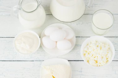 Beyaz tahta tahtalarda farklı süt ürünleri, bulanık arka plan.