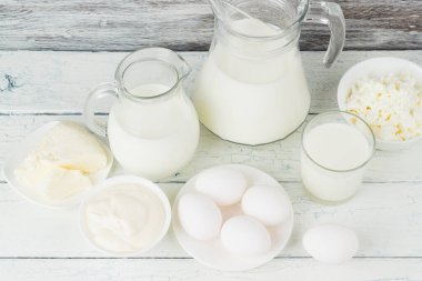 Beyaz tahta tahtalarda farklı süt ürünleri, bulanık arka plan.