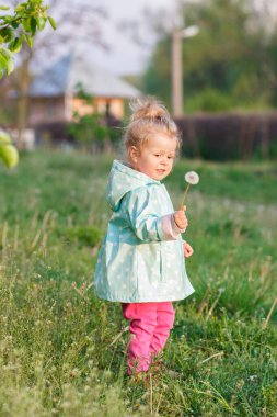 Parktaki küçük tatlı kız, yumuşak odaklı arka plan.