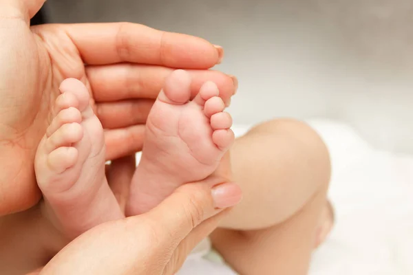 Kadının Elleri Bebek Ayağını Tutuyor Yumuşak Odaklı Arka Plan — Stok fotoğraf