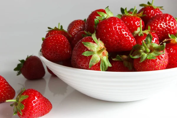 Beyaz kase kırmızı olgun çilek, ışık arka plan