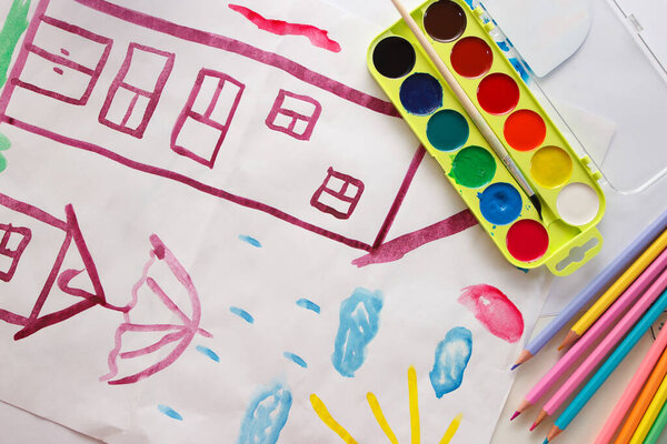 Child drawing a picture by watercolor, back to school concept