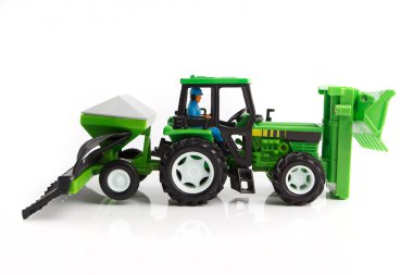 Beyaz arka planda küçük traktör oyuncağı, hasat konsepti