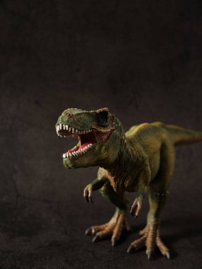 Tyrannosaurus figürü ve yeşil orman