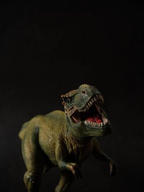 Tyrannosaurus figürü ve yeşil orman