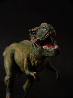 Tyrannosaurus figürü ve yeşil orman