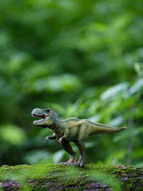 Tyrannosaurus figürü ve yeşil orman