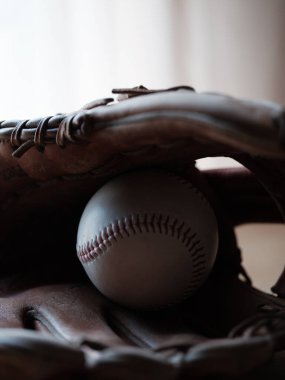 Eldiven ve beyzbol topu masada.