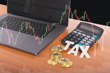 Vergi BTC şifreli para birimi, hesap makinesinin önünde dizüstü bilgisayarın önünde ve stok grafik arka planında