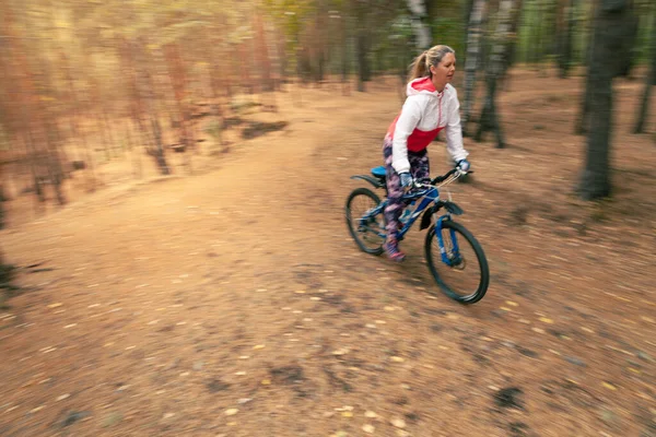 La chica monta en bicicleta a alta velocidad. Desenfoque dinámico del fondo — Foto de Stock