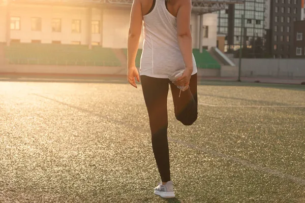 Sports girl doing stretching on the stadium lawn — Stock Photo, Image