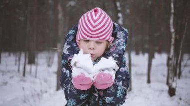 Kız elinde bir tutam kar tutuyor ve üfleyerek üflüyor. Noel 'den önce çocuk oyunları