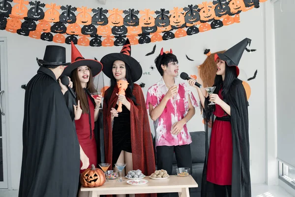 아시아 청년들이 복장을 할로윈 파티를 축하하는 마법사가 방에서 노래하고 마시고 — 스톡 사진