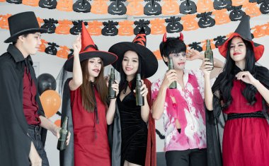 Genç Asyalı kostümlü cadı çetesi, Cadılar Bayramı partisini kutlayan büyücü dans ve içki için odada sarhoş. Gençler ve Taylandlılar Cadılar Bayramı 'nı kutluyor. Kavram partisi Cadılar Bayramı evde.