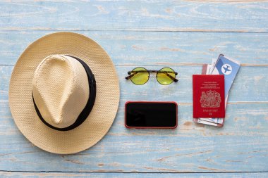 Ahşap arka planda gezginler için kullanılan aksesuarların üst görüntüsü. Seyahat aksesuarları ve kopyalama alanı. Üst görünüm seyahat aksesuarları kavramı.