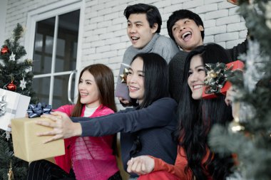 Genç Asyalı grupların mutlu bir partisi ve evde Noel festivali için hediyeler. Taylandlı gençler Noel 'i ve yeni yılı kutluyorlar. Mutlu Noeller ve mutlu Noeller..