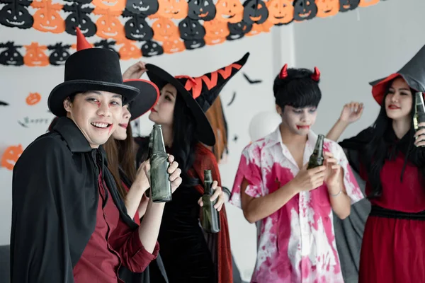 衣装の魔女で若いアジア人のギャング ダンスや飲み物のためのハロウィンパーティーを祝い 部屋で酒を飲むウィザード ハロウィンを祝うグループ10代タイ コンセプトパーティー ハロウィーンアットホーム — ストック写真