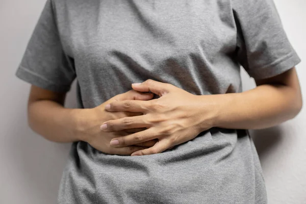 Karın ağrısı çeken bir kadın. Adet nedeniyle karın ağrısı çeken genç bir kadın. Mide iltihabına bağlı karın ağrısı..