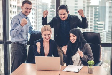 Bir grup ofis çalışanı dizüstü bilgisayarlarında bir gülümsemeyle ve arka planda şehir binalarıyla birlikte başarılı bir şekilde çalışıyorlar. Ofis çalışanları grubunda başarılı olduğuna sevindim..