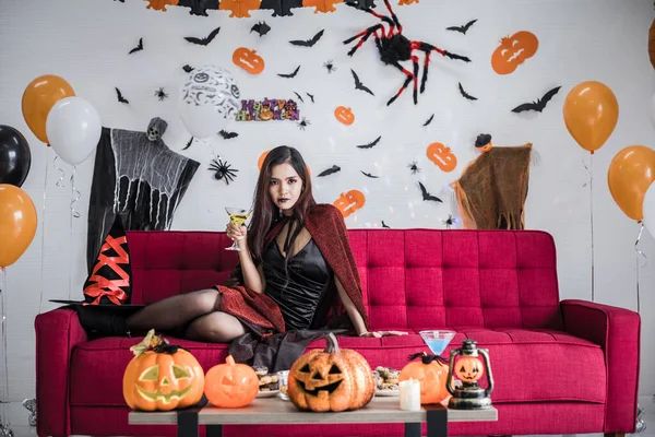 Young Asian Woman Costume Witch Sit Red Sofa Hold Wine — Stockfoto