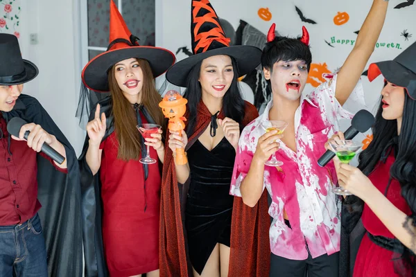 衣装魔女の若いアジア人のギャング 歌と飲み物 部屋のデザートを歌うためのハロウィンパーティーを祝うウィザード ハロウィンを祝うグループ10代タイ コンセプトパーティー ハロウィーンアットホーム — ストック写真