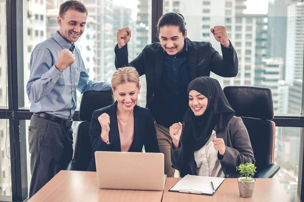 Bir grup ofis çalışanı dizüstü bilgisayarlarında bir gülümsemeyle ve arka planda şehir binalarıyla birlikte başarılı bir şekilde çalışıyorlar. Ofis çalışanları grubunda başarılı olduğuna sevindim..