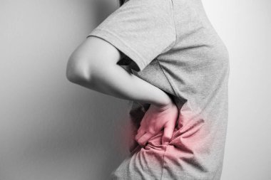 Belinde ağrı olan bir kadın. Sırt ağrısı çeken bir kadın. Ani sırt ağrısından muzdarip.