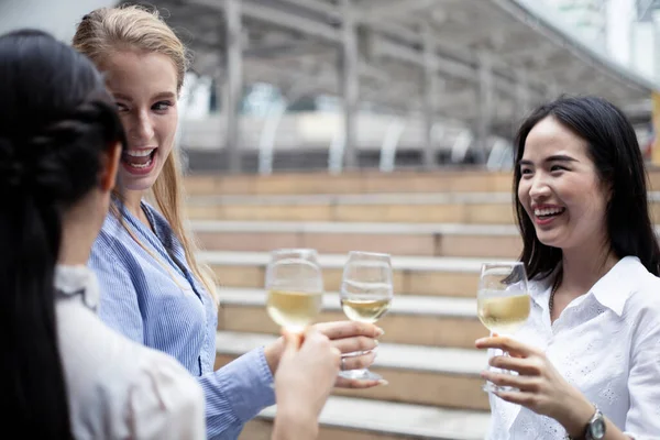 İş adamları başarılarını kutlamak için kadeh tokuşturur ve şarap içerler. Bir grup iş adamı bunu şarap içerek kutluyor..