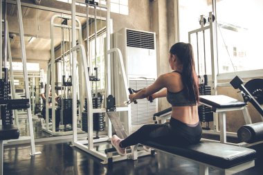 Modern spor salonunda egzersiz makinesiyle seksi kadın egzersizi. Spor salonundaki kadın spor salonu. Egzersiz yaparak sağlığına dikkat eden Asyalı bir kadın. Vücut geliştirme konseptiyle sağlıklı bakım.