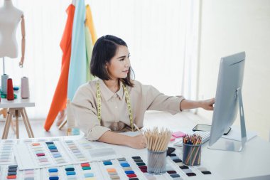 Designer are thinking and designing clothes for customers order items at the designer desk in the studio. Clothes designers are working in the office. Startup designer concept.
