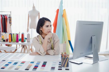 Designer are thinking and designing clothes for customers order items at the designer desk in the studio. Clothes designers are working in the office. Startup designer concept.