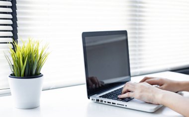 Hand of woman while typing on laptop with working from home. Work at home concept. Remote working on laptop in the home. business online. work online.