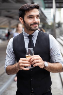 İşadamı başarılı işi kutlamak için şarap içer. Beyaz adam bunu şarap içerek kutluyor..