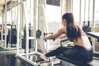Modern spor salonunda egzersiz makinesiyle seksi kadın egzersizi. Spor salonundaki kadın spor salonu. Egzersiz yaparak sağlığına dikkat eden Asyalı bir kadın. Vücut geliştirme konseptiyle sağlıklı bakım.