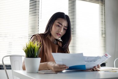 Genç Asyalı kadın, birçok kredi kartı ve fatura borçlarından dolayı stresli ve fazla kafa yoruyor. Finansal sorun kavramı. Kadınlar borçtan kurtulmanın bir yolunu buldular..