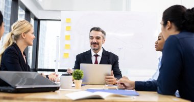 Şirket işletme ekibi ve müdürüyle toplantı odasında. İş adamları ofiste toplantı sırasında konferans odasında tartışırlar..