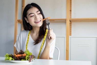 Happy woman holding dish vegetable for healthy diet with smile in healthcare. Eating fresh organic vegetarian salad.