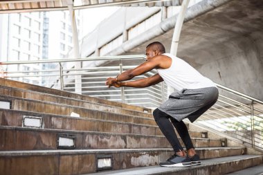 Fit runner African American young man training by upstairs at the stadium. Handsome young man exercise outdoors.